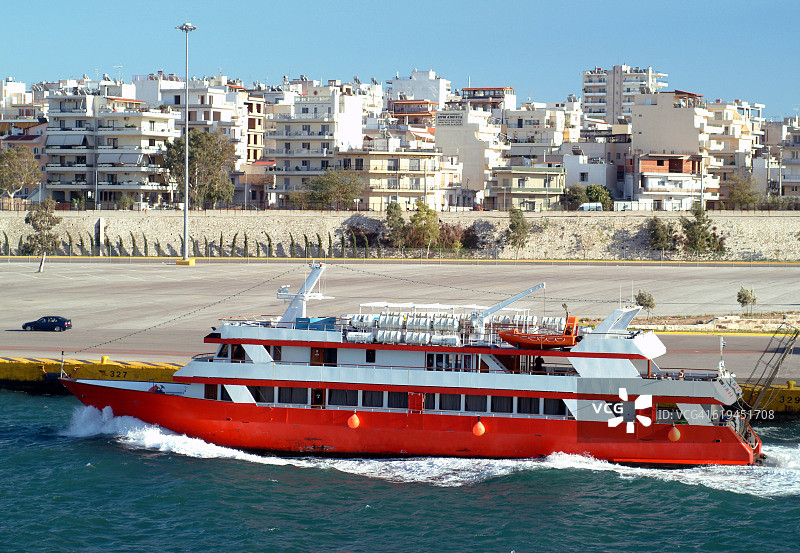 雅典欧洲，比雷埃夫斯港，希腊，红色船与公寓楼的背景图片素材