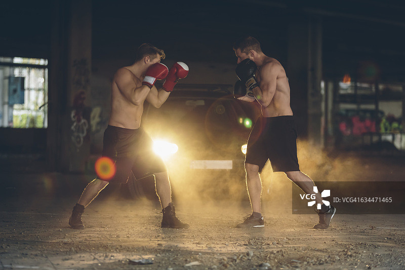 两个拳击手在一个废弃的工厂里打架图片素材