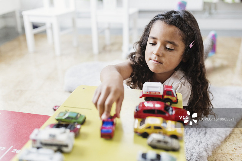 小女孩在日托中心玩玩具车图片素材