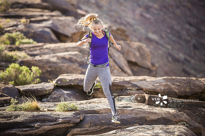 一个白人女人在岩层上奔跑图片素材