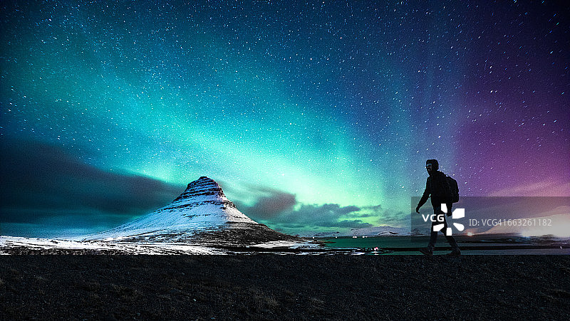 冰岛基尔丘山的北极光落在一名男子的身上图片素材