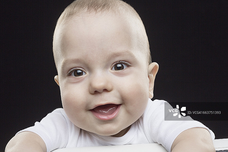 黑色背景下快乐男婴的肖像图片素材