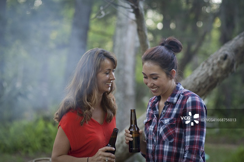 两个女人在篝火旁喝啤酒图片素材