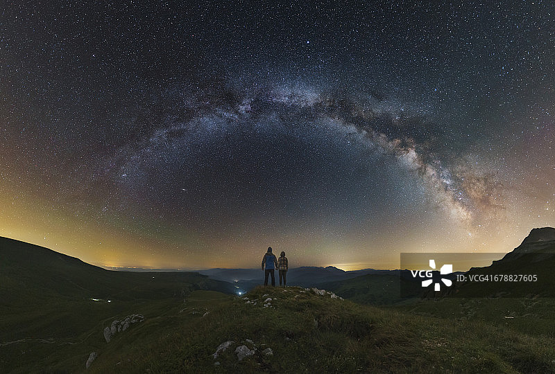 一对夫妇从拉各斯-纳基高原上俯瞰俄罗斯，凝视着银河。图片素材