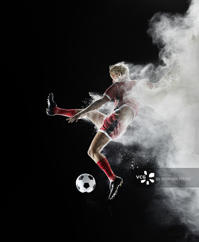 年轻的足球运动员在空中带着白色的粉末图片素材