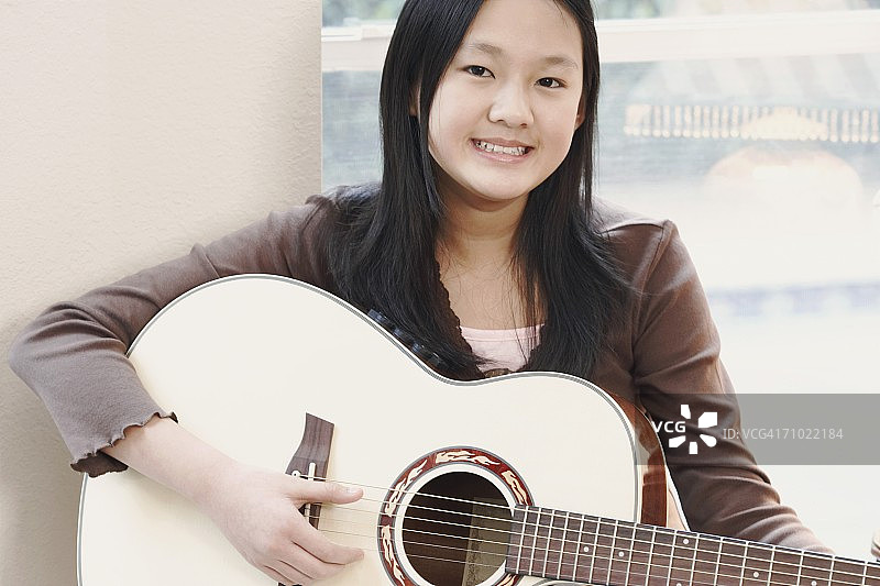 一个弹吉他的女孩的肖像图片素材
