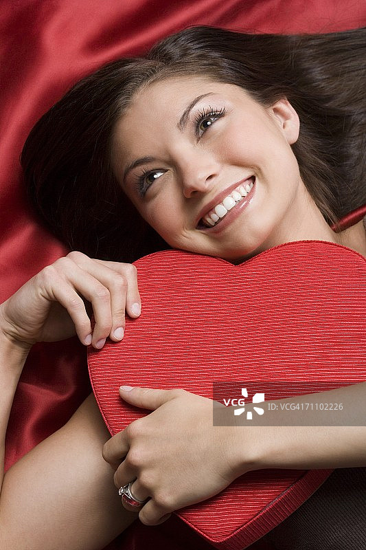 高角度的一个年轻女子与一个心形的盒子图片素材