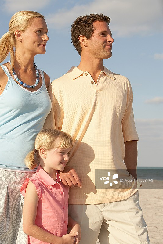 女孩和父母在海滩上图片素材