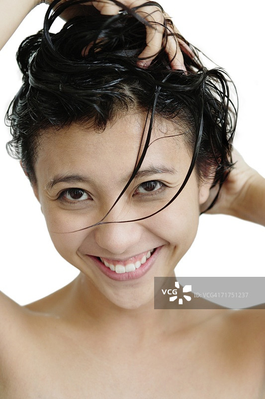 一个女人在洗她的头发，看着相机图片素材