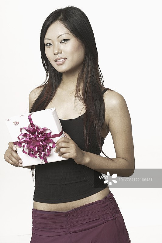 一个年轻女子拿着礼物的肖像图片素材