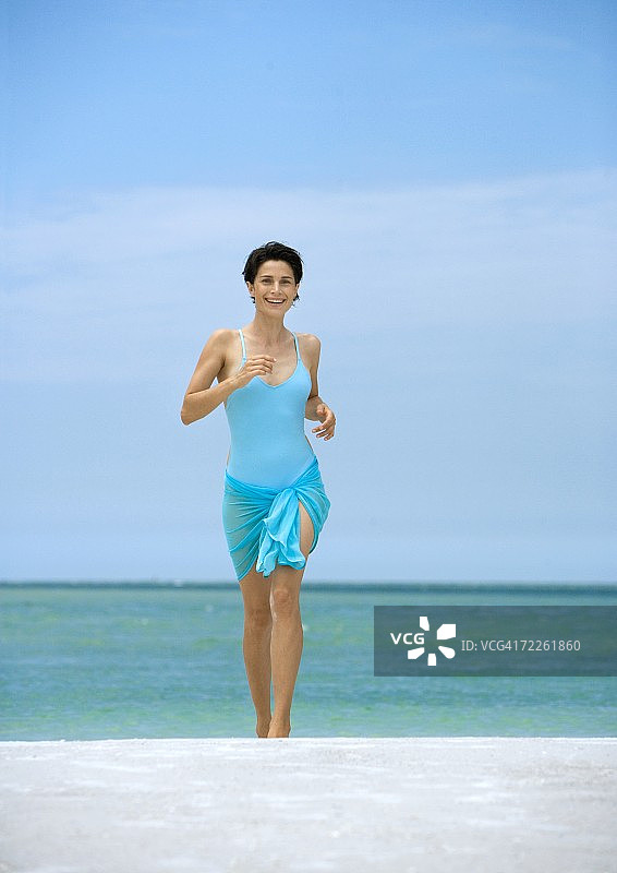 在海滩上跑步的女人，正面图片素材