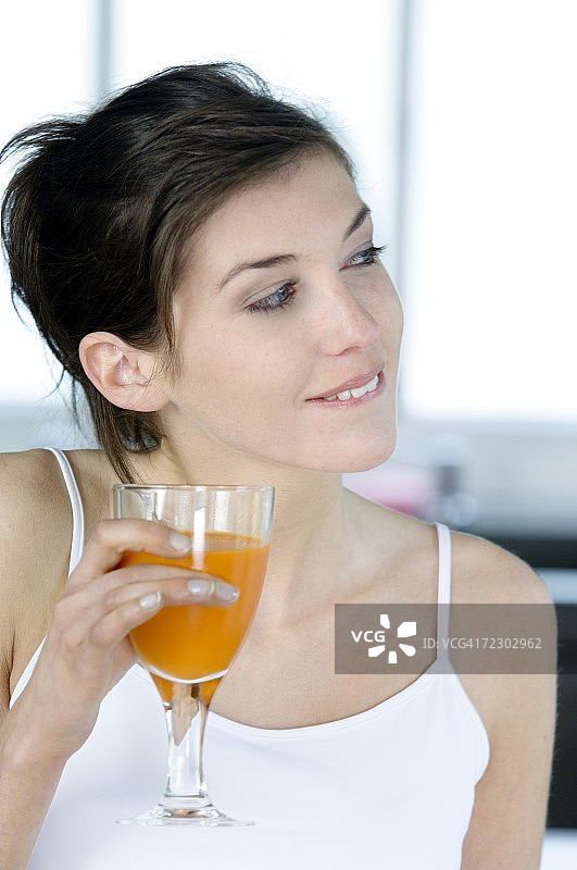 一个拿着一杯橙汁的女人的肖像图片素材