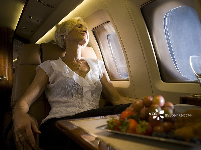 一位在飞机上睡觉的老妇人图片素材