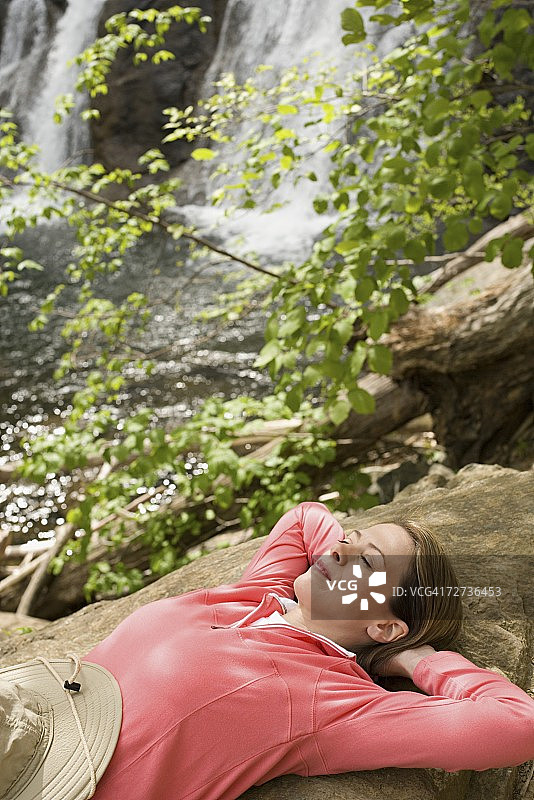 在瀑布附近休息的女人图片素材