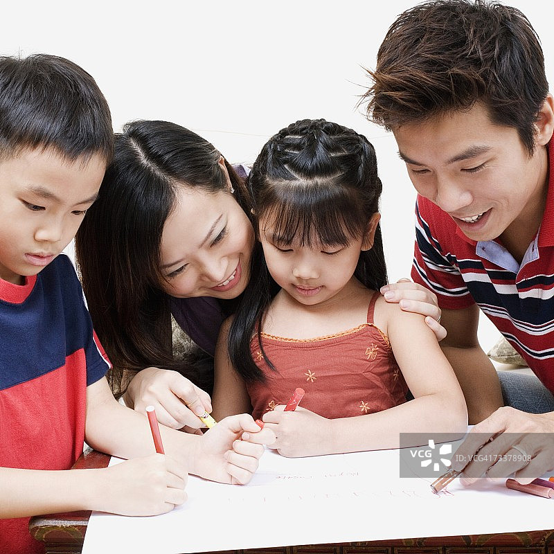 父母教一个男孩和一个女孩如何着色的特写图片素材