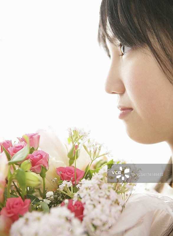 日本年轻女子捧着花束，画像图片素材
