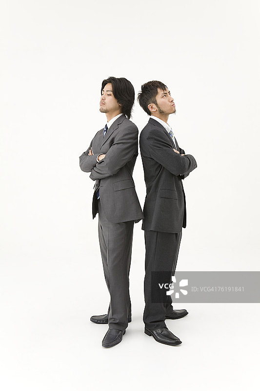 两个商人背靠背站着图片素材
