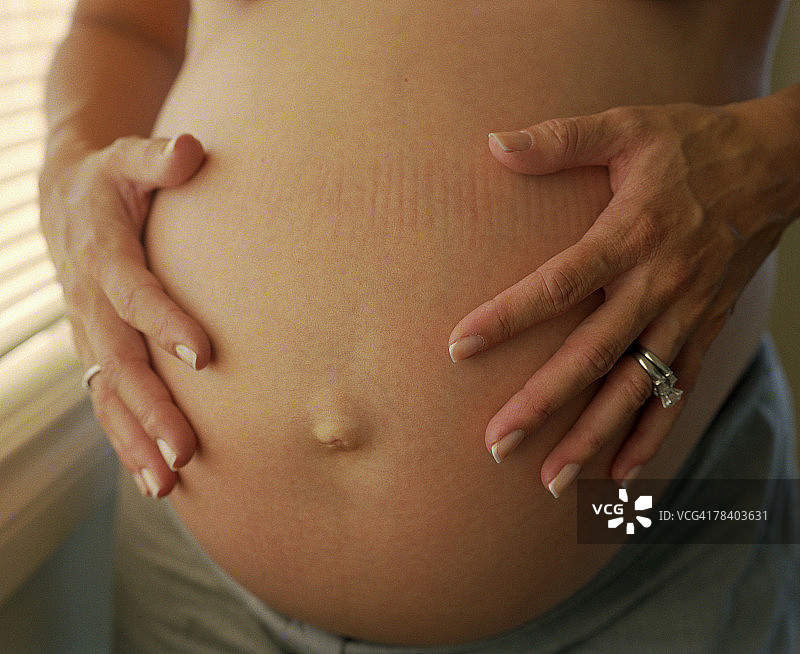 抱着孕妇肚子的女人图片素材