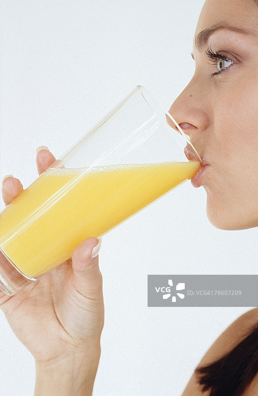 女人喝一杯橙汁图片素材