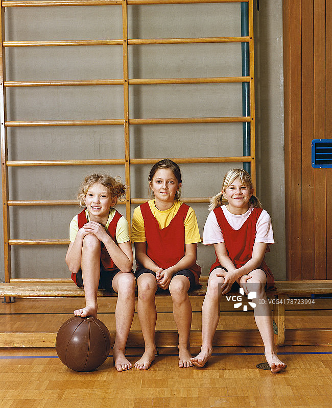 三个女孩坐在体育课上图片素材