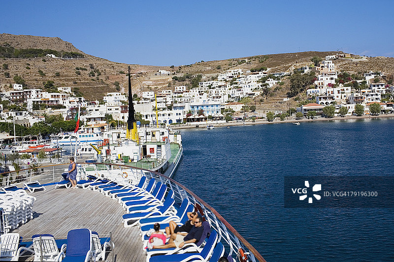 高角度的游客休息在船上甲板的躺椅上，斯卡拉，帕特莫斯，十二岛群岛，希腊图片素材
