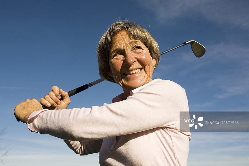 手持高尔夫球棒的成年妇女图片素材
