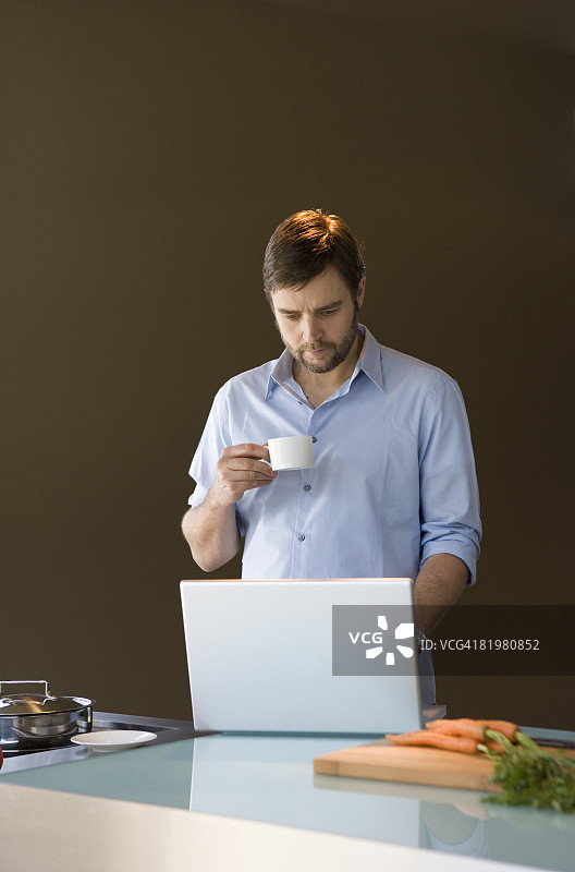 一个拿着咖啡杯拿着笔记本电脑的男人图片素材