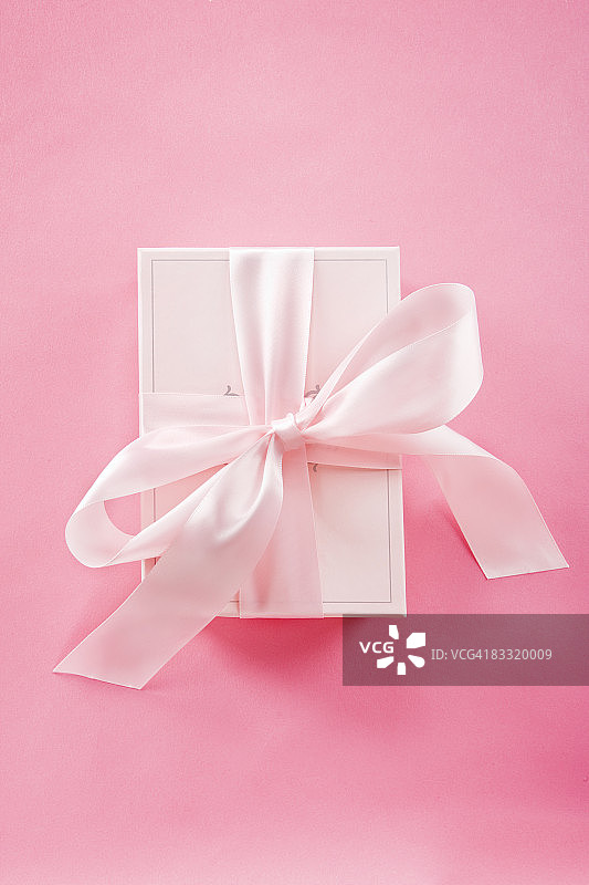 粉红色的礼物和粉红色背景上的丝带图片素材