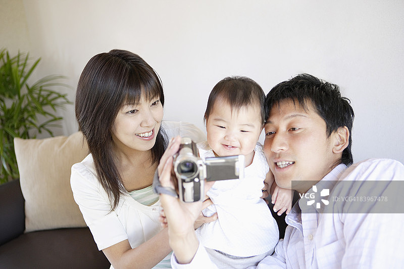 父母和婴儿看着视频监控图片素材