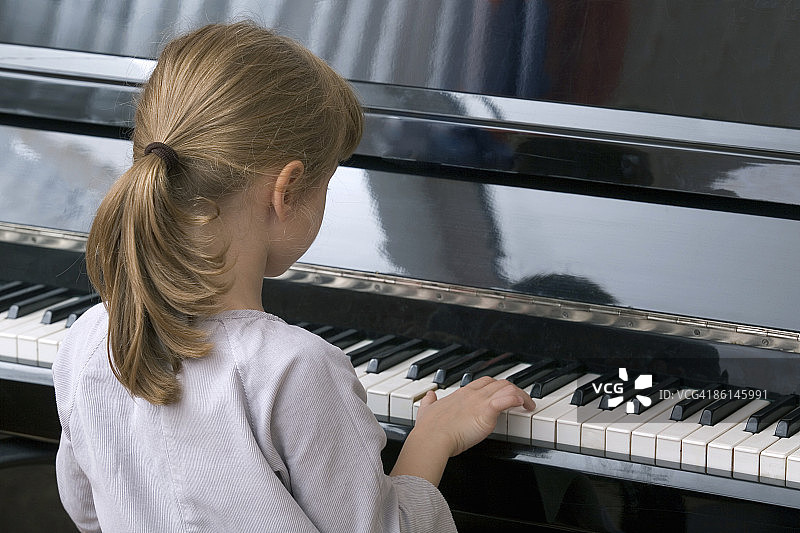 一个年轻的女孩在弹钢琴图片素材