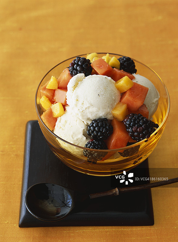 香草冰淇淋加上新鲜木瓜，芒果和黑莓图片素材