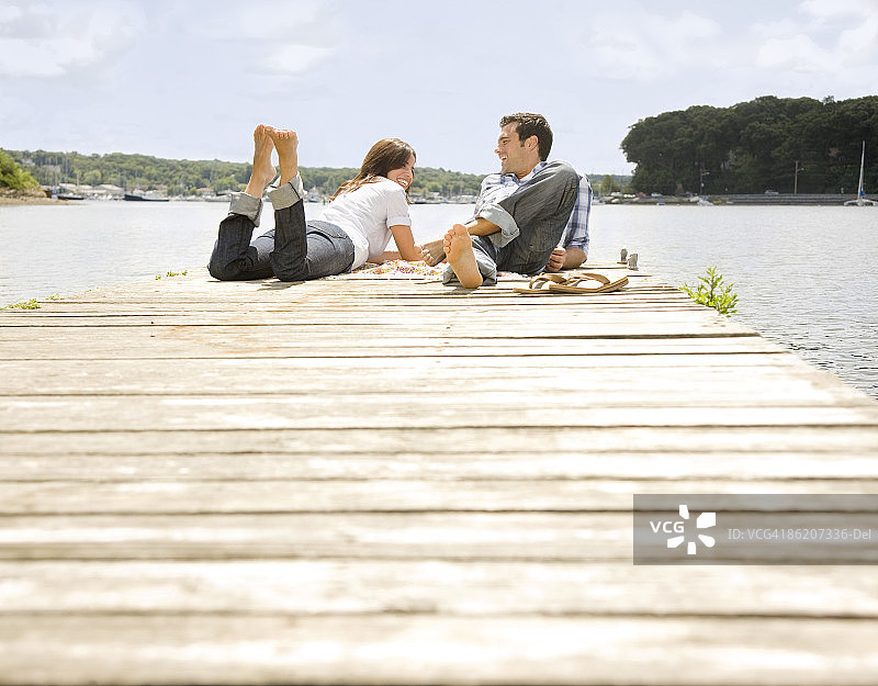 一对夫妇躺在码头上图片素材