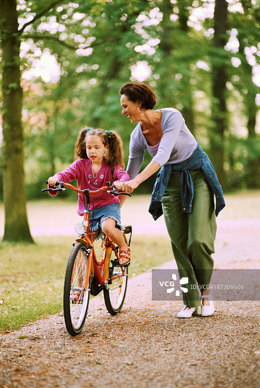女孩和她的妈妈骑自行车图片素材