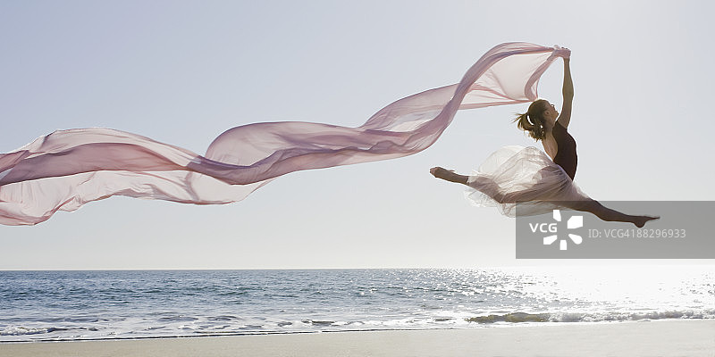 舞者在海滩上跳跃图片素材