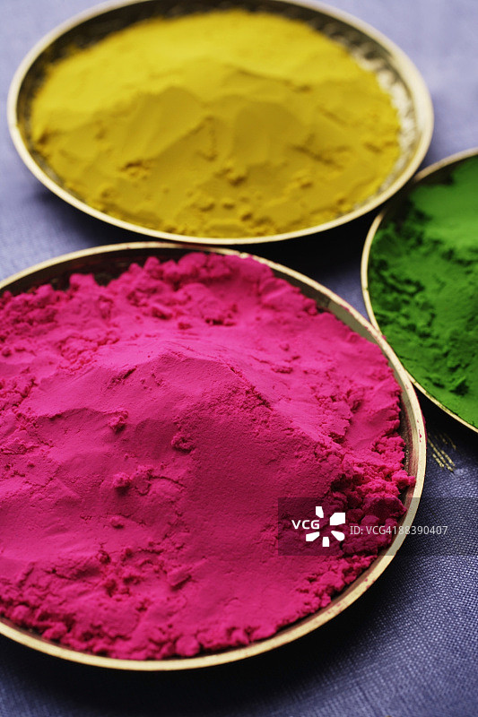 粉色，黄色和绿色的印度粉末的特写图片素材