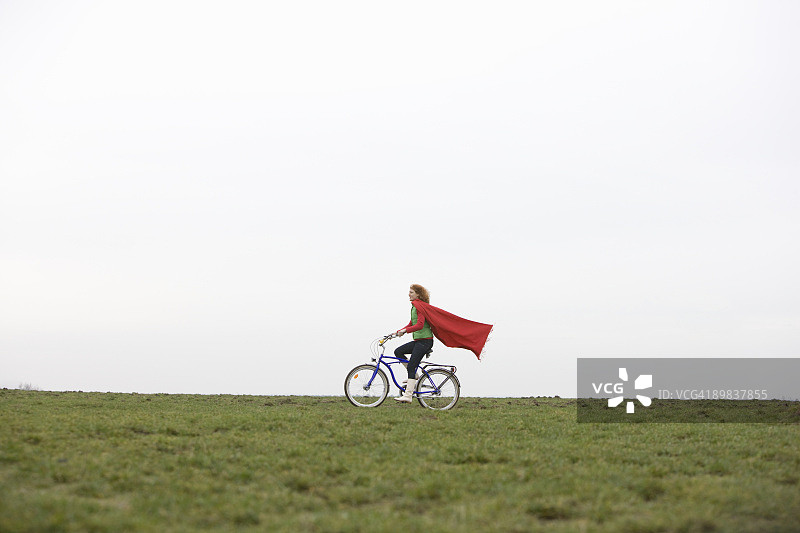 一个女人骑着自行车穿过公园图片素材