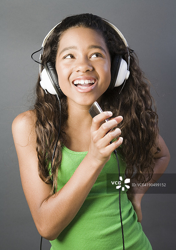 少女戴着耳机跟着音乐唱歌图片素材