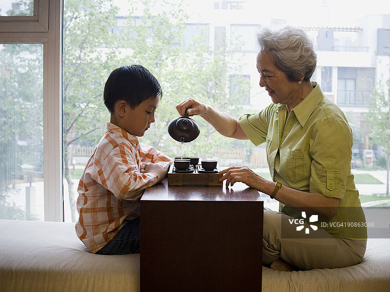 奶奶和孙子围坐在一起喝茶图片素材