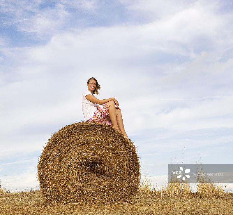 女人坐在干草堆上图片素材