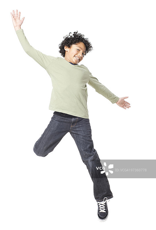 男孩(8-9)在白色背景下跳跃图片素材