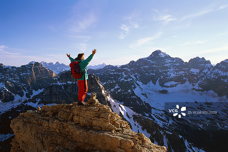 女人站在山顶，双手伸着图片素材