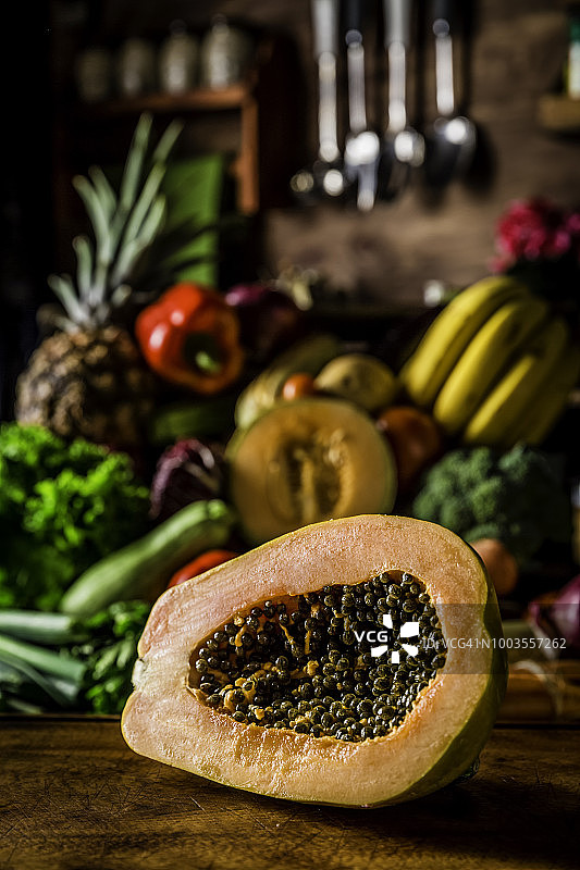 什锦有机热带水果和蔬菜在一个乡村厨房的背景。自然采光图片素材