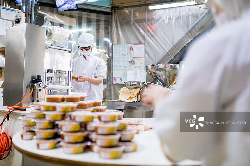 食品加工厂中包装食品的工人图片素材