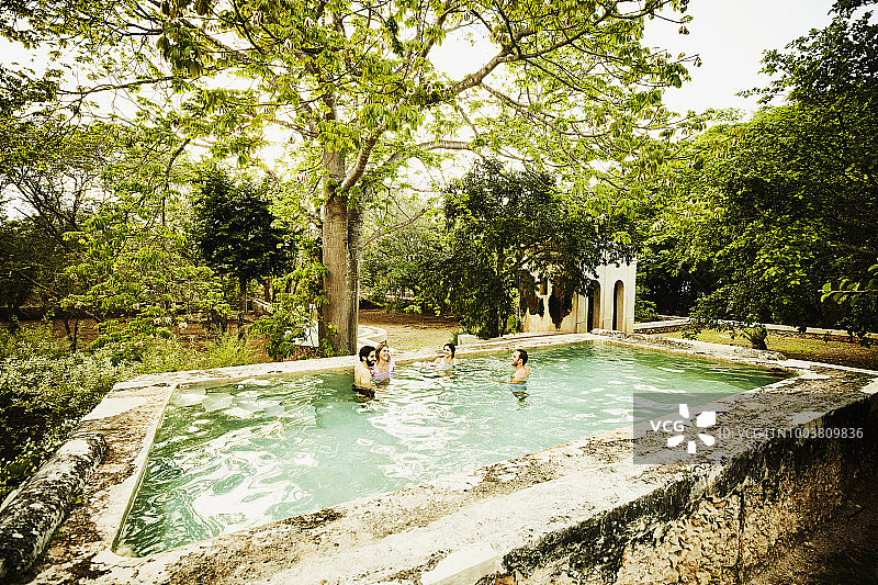 两对情侣一起在豪华热带度假村的游泳池里闲逛图片素材