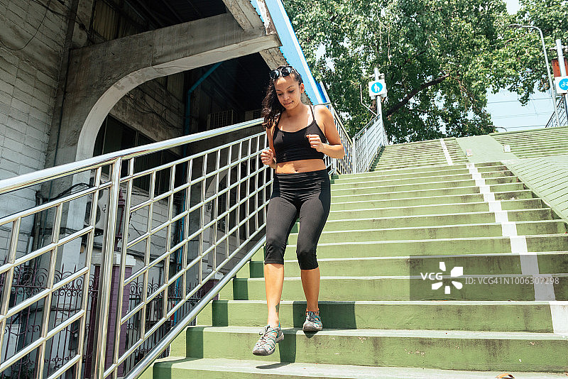 锻炼千禧一代西班牙裔美国妇女在户外跑下楼梯图片素材