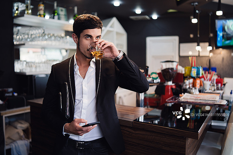 在酒吧里喝威士忌的绅士图片素材