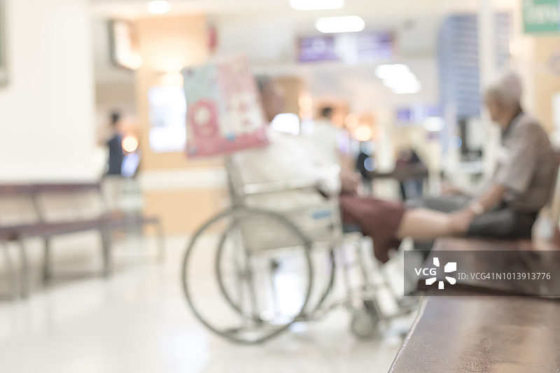 模糊诊所或医院候诊室和走廊的背景，护士站附近有轮椅上的病人图片素材