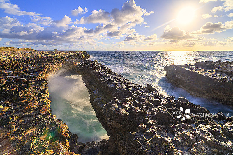 日出时，汹涌的加勒比海被悬崖包围，安提瓜的魔鬼桥图片素材