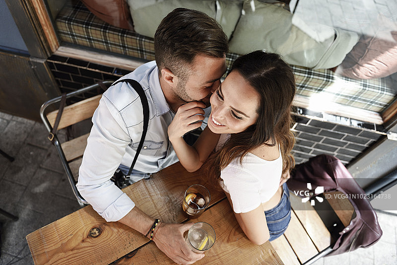一对深情的情侣在城市的一个户外酒吧喝酒图片素材