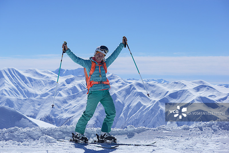 在格鲁吉亚高加索山脉的特特努尔迪滑雪胜地，手持滑雪杆的女滑雪者举起了手臂图片素材
